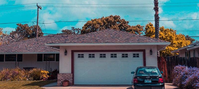 A garage with a car in the driveway