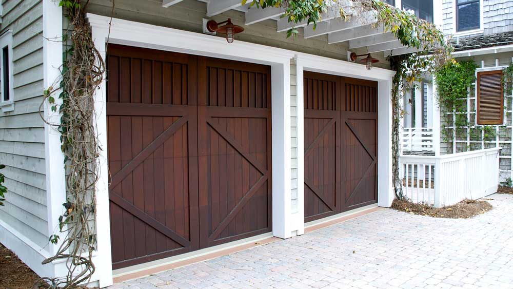 Two side-by-side wooden doors on a white garage.