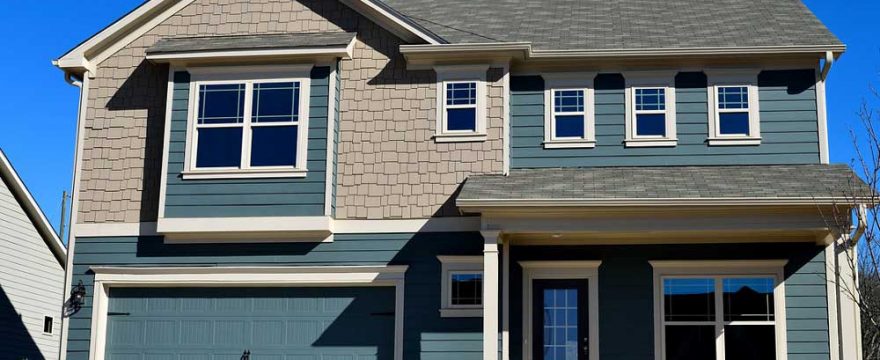 A blue house with an attached garage. The garage door is also blue.