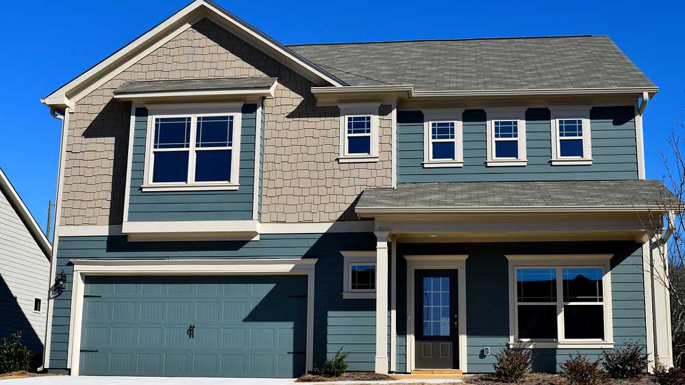 A blue house with an attached garage. The garage door is also blue.