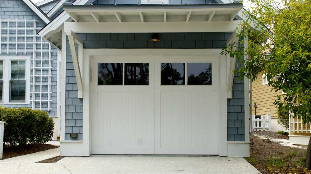 A small blue garage with white doors.