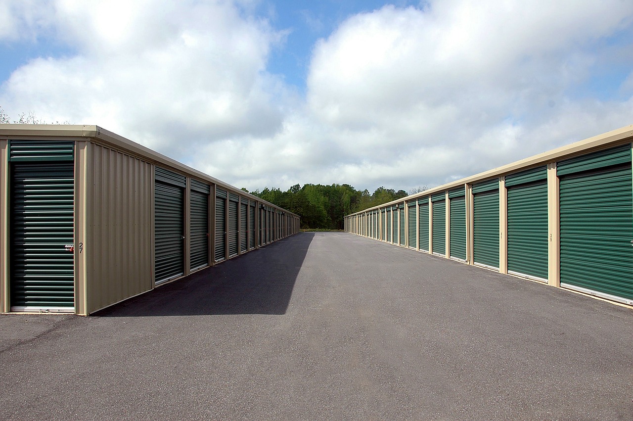 Rows of outdoor storage units with green aluminum doors