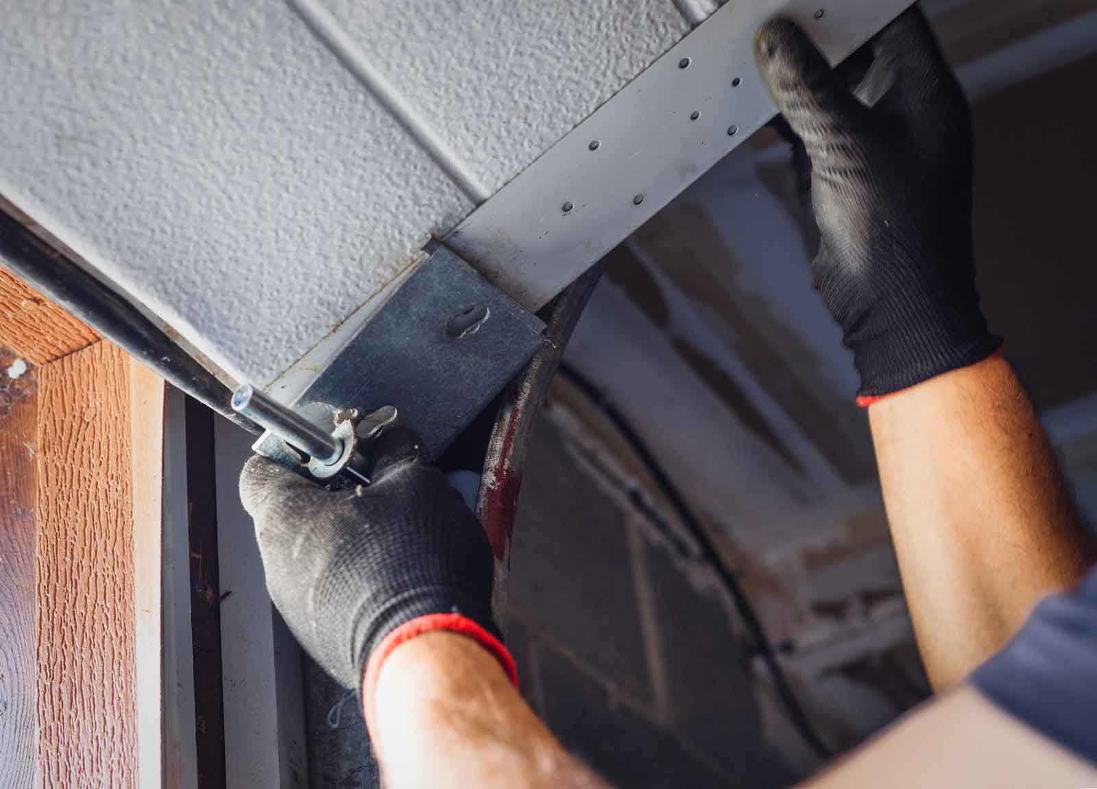 Garage door repair technician re-setting garage door on to it's track